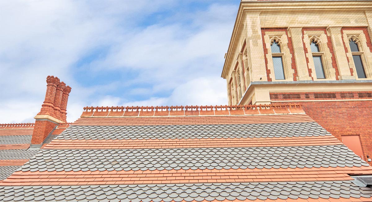 bands of plain Staffordshire red tiles with ornamental Staffordshire blue spade and fishtail tiles twice winner Pitched Roofing Award winner 2021