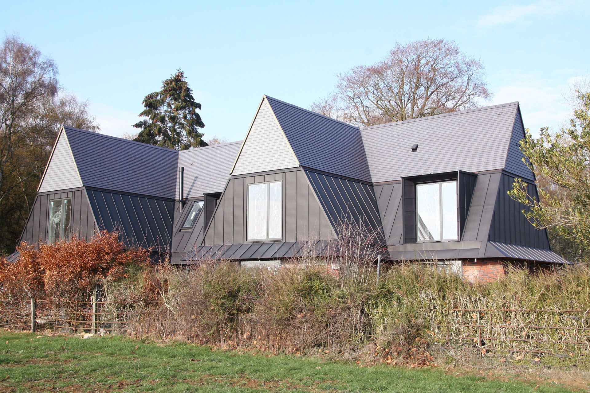 A striking roof with Staffs blue smooth tiles and zinc on a steeply pitched roof