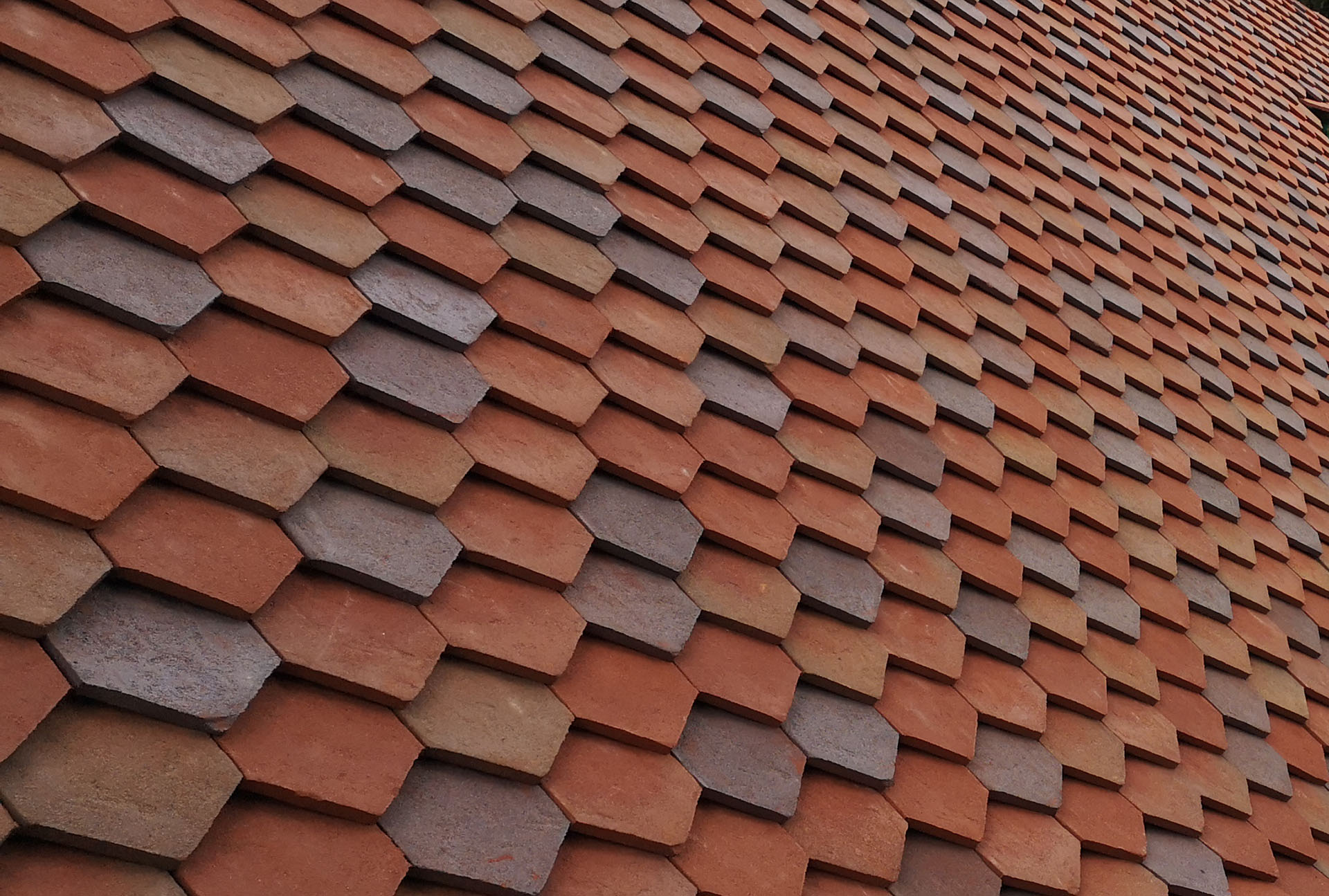 a mixed blend of handmade arrowhead tiles in bronze purple brown dark heather and red St Edwards Oxford