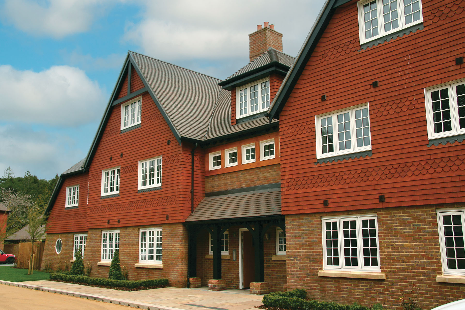 red rustic vertical tiling on a a small residential development